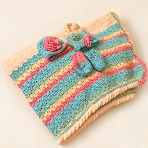 A pastel crochet blanket, hats, and booties handmade by Jackie Rivera